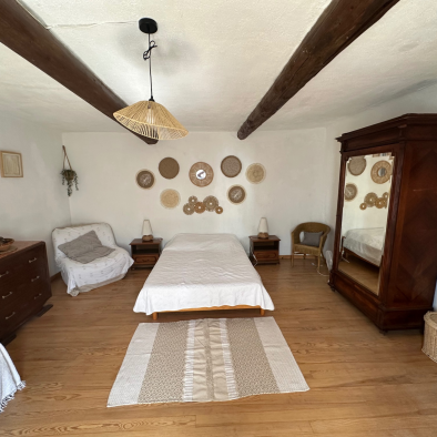 Chambre principale La Jas de Hubert Domaine Degoutaud avec lit double poutres apparentes et décoration provençale